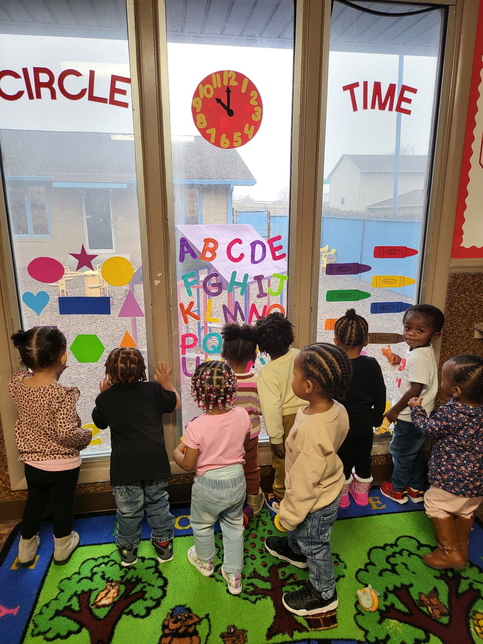 Children learning the alphabet at the classroom window during circle time