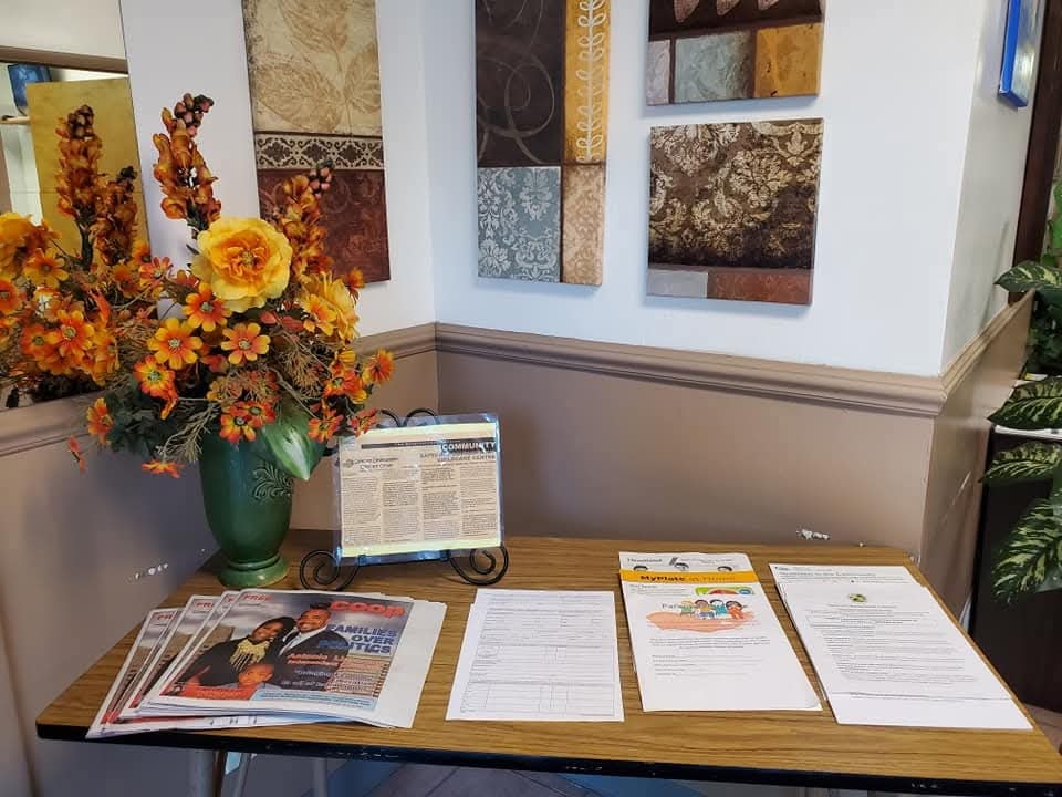 Welcome table in the lobby with community newsletters, family resources, and floral arrangement