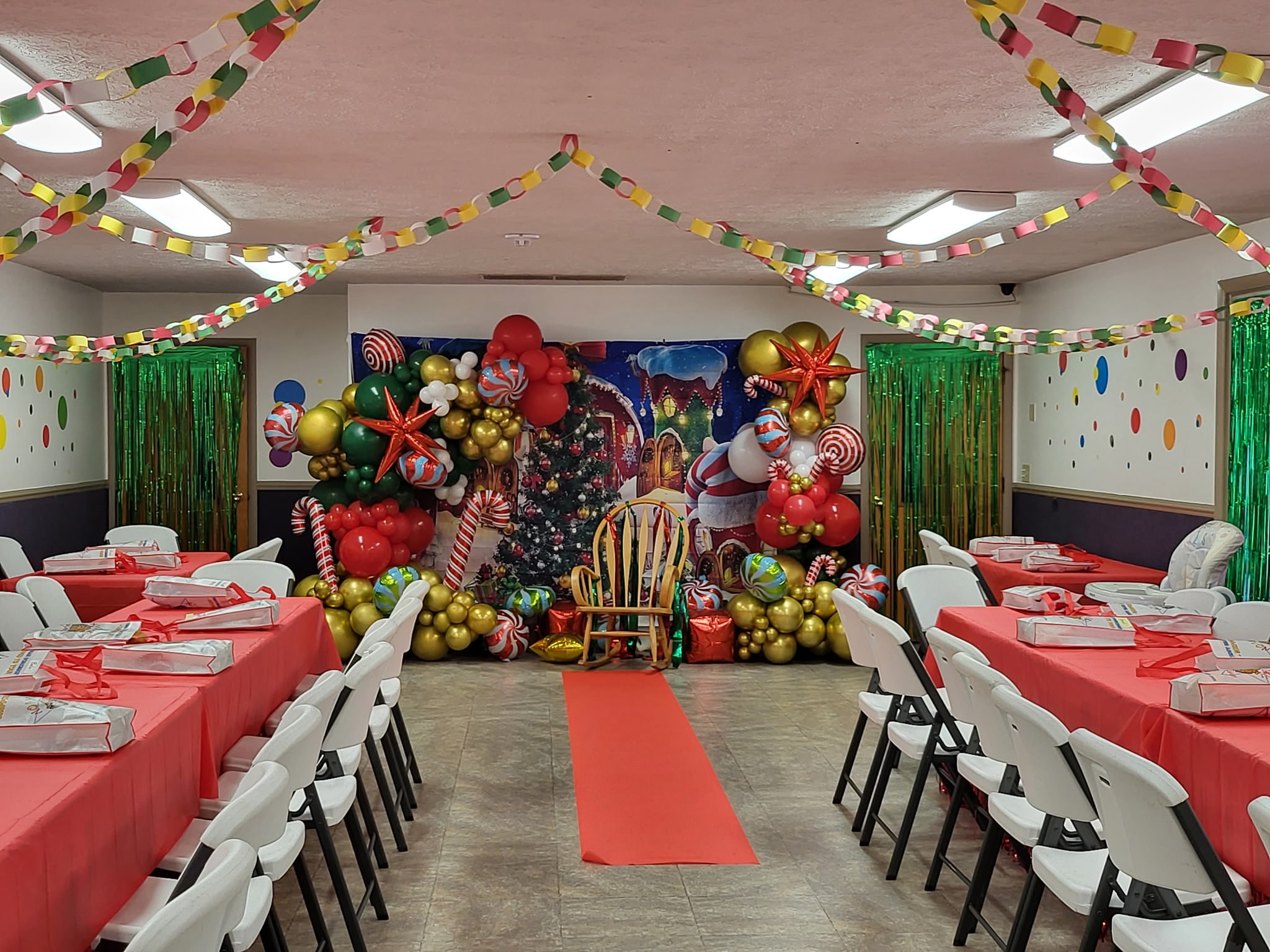 Festive holiday banquet hall with balloon arch photo backdrop and red carpet at Safecare