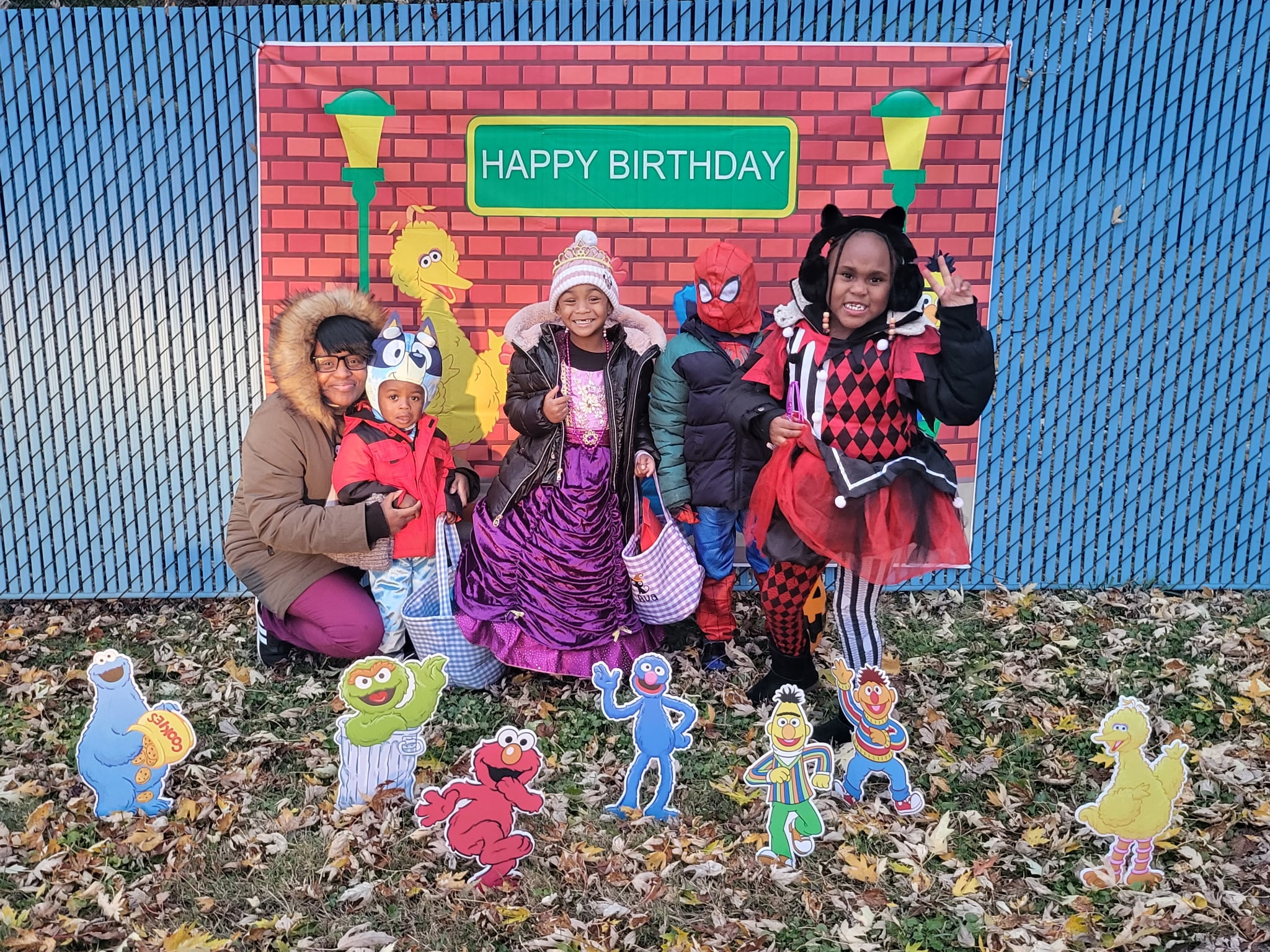 Children in costumes posing in front of a Sesame Street Happy Birthday backdrop at Safecare
