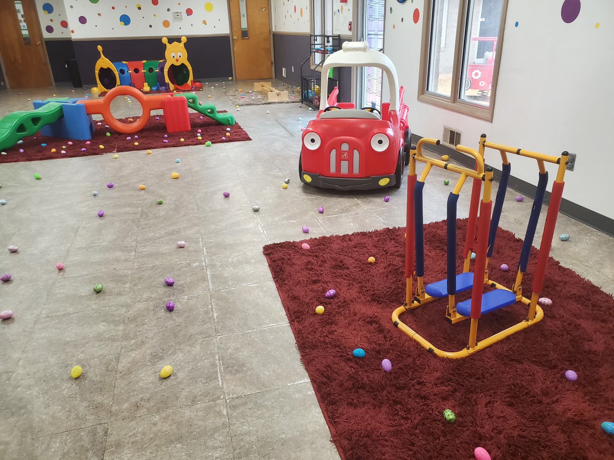 Indoor Easter egg hunt with colorful eggs scattered across the play area floor at Safecare
